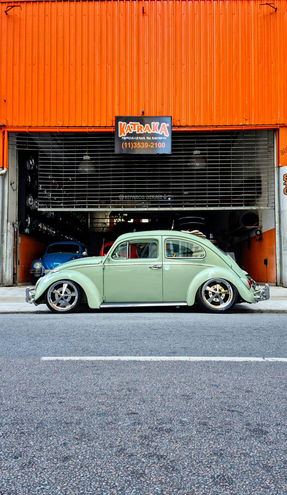 Fachada laranja da Katraka com fusca verde na garagem