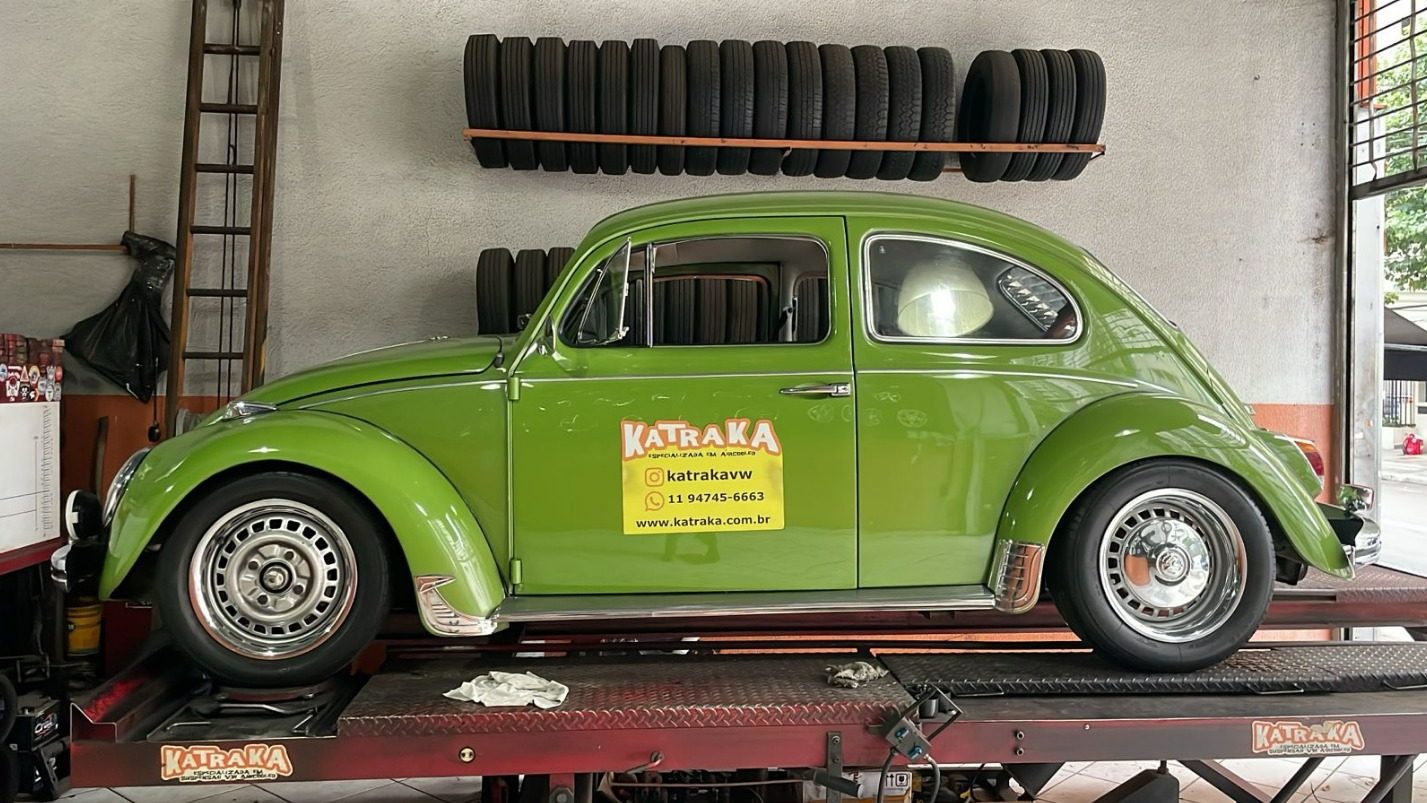 Fusca verde sobre a rampa de alinhamento da Katraka, com pneus na parede ao fundo